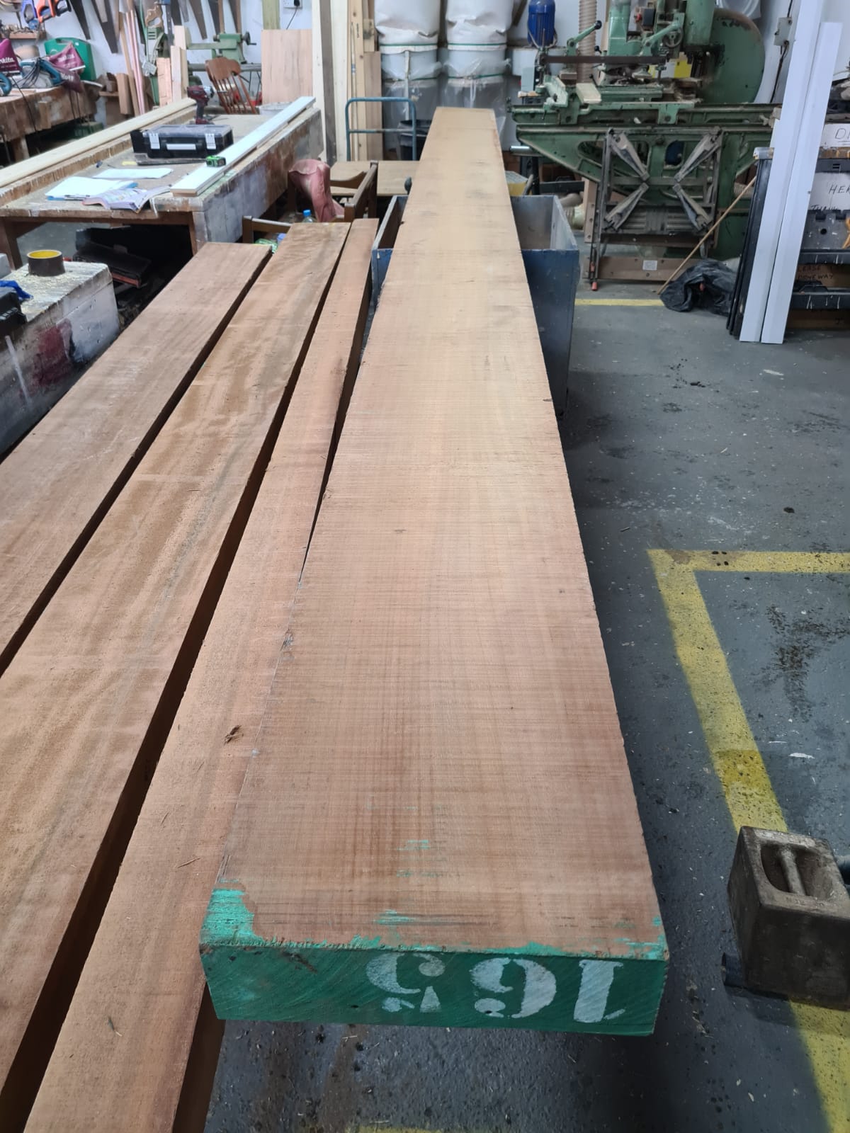 Long hardwood boards laid out in the workshop